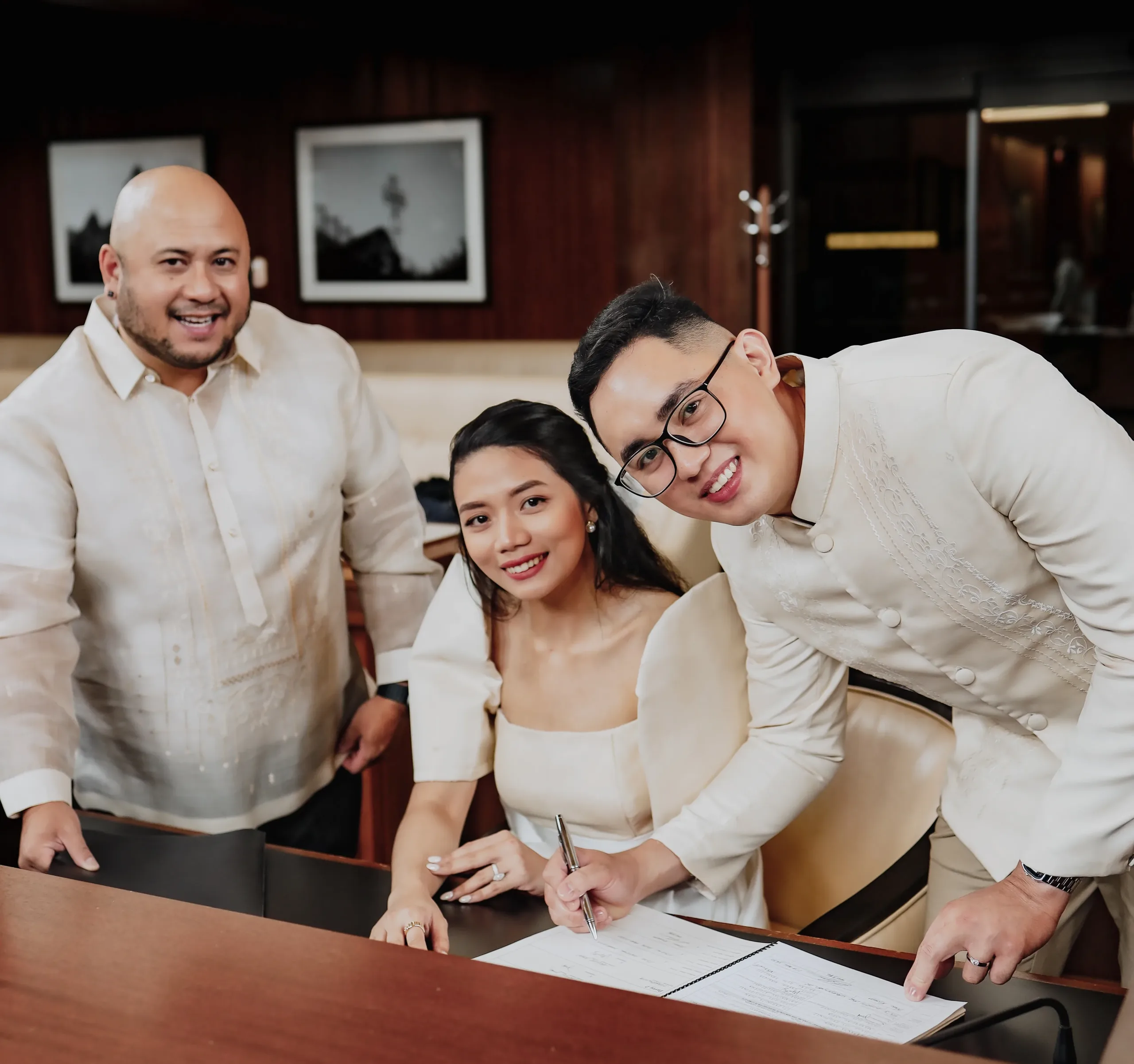 Couple signing marriage certificate with officiant